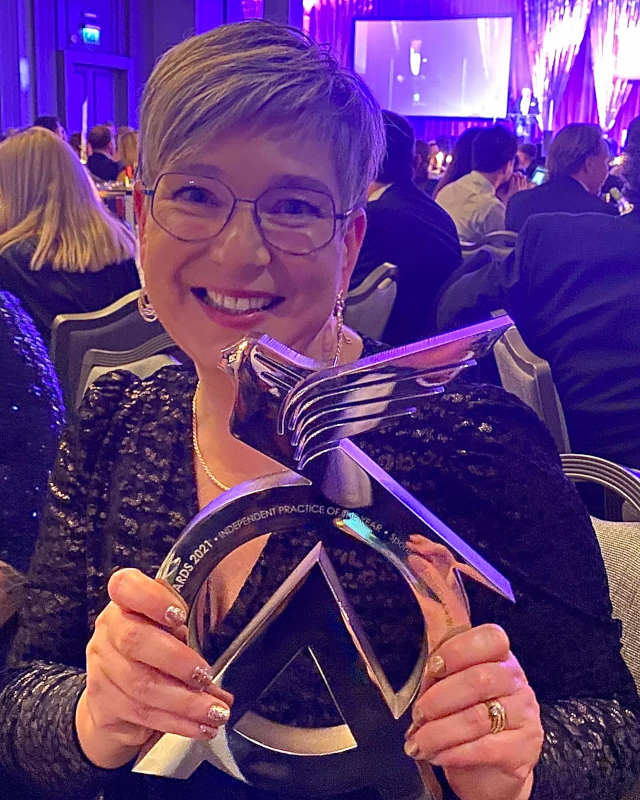 Anita holding the Optician Awards trophy