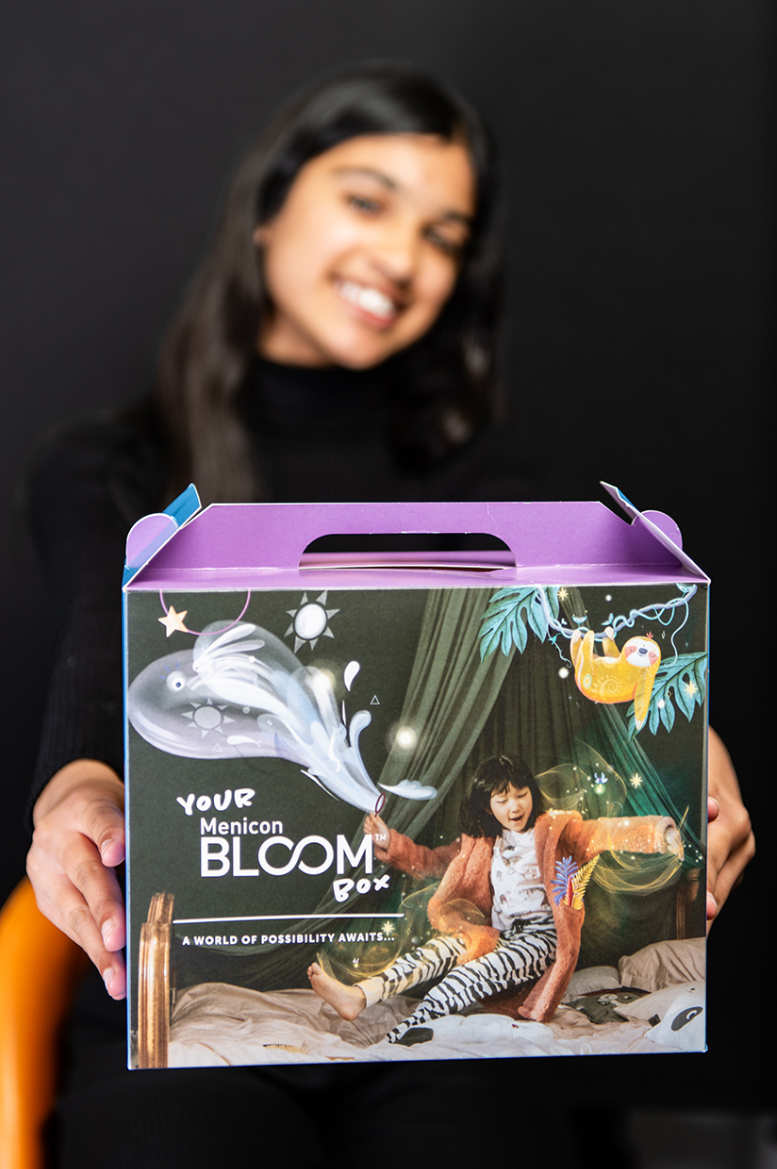 Young girl holding Menicon Bloom package to prevent Myopia development