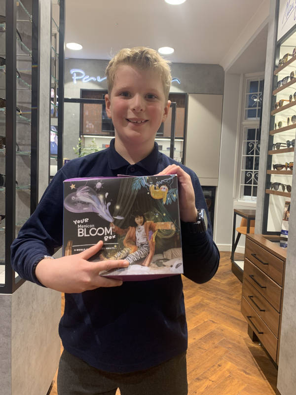 Young boy holding Menicon Bloom package to prevent Myopia development
