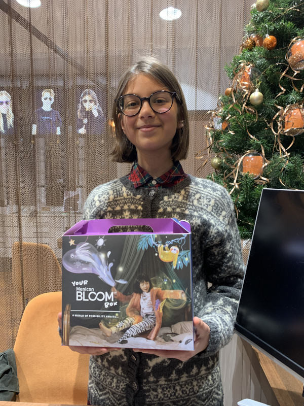 Young girl holding Menicon Bloom package to prevent Myopia development